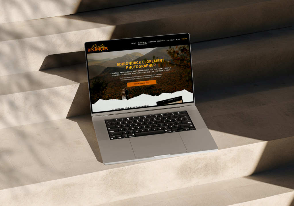 A laptop showcasing the header of a homepage for an elopement photographer that sits on smooth stone steps cast into sunlight